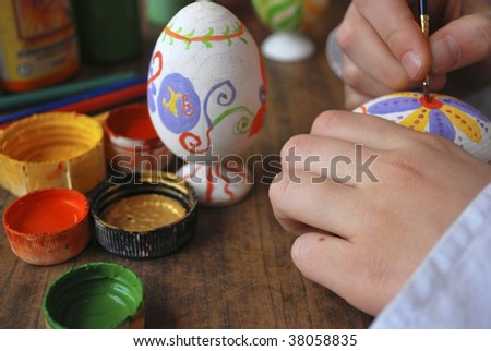 the girl enterring wooden egg, hands with paints