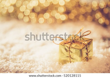 Christmas retro gold box in the snow with golden background light