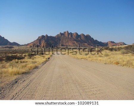 Namibian gravel road with mountains in background, Africa