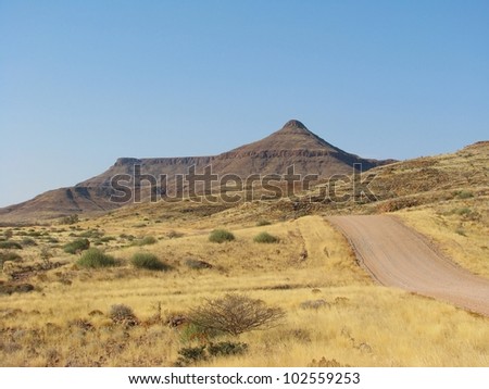 Namibian gravel road with mountains in background, Africa