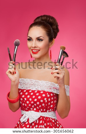Beauty Girl with Makeup Brushes. Natural Make-up for Brunette Woman. Beautiful Face. Makeover. Perfect Skin. Pin-Up Retro style.