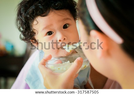 Asian baby children girl with curly hair feeding