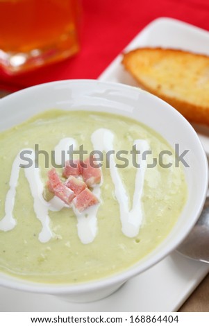 The bowl of soup and bread in dish on the table.