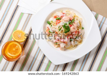 Spaghetti with seafood and water on the table.