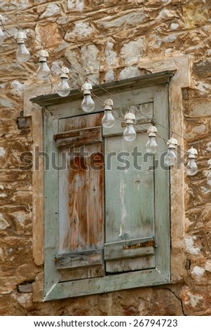 A string of light bulbs strung across a shuttered window
