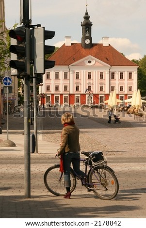 a girl with a bike waiting to cross the road