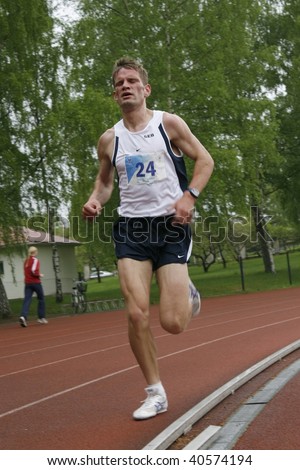 TARTU, ESTONIA - MAY 20TH: Athlete running along the track and taking part in Student Sell Games, organized by Estonian Academic Sports Federation in May 20th, 2006 in Tartu, Estonia.