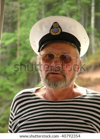 Old seaman with a white hat and stripy shirt