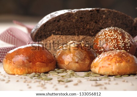 variety of small breads with seeds and bread on background