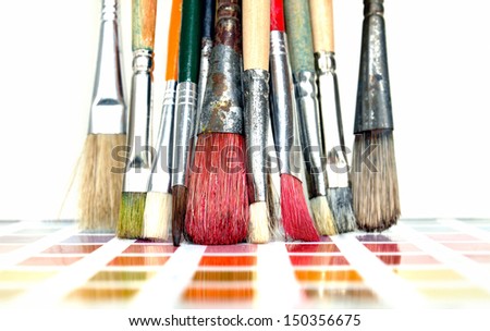 Group of used artist paintbrushes on a color guide