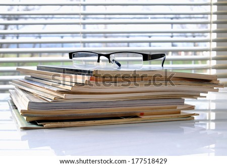 Stack of magazines in front of office window