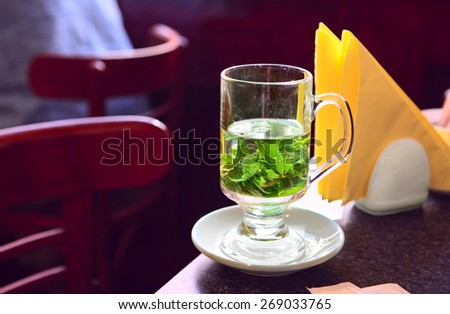 Transparent cup of mint tea on the table in cafe