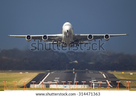 Passenger Jet taking off from a runway with dark clouds behind.