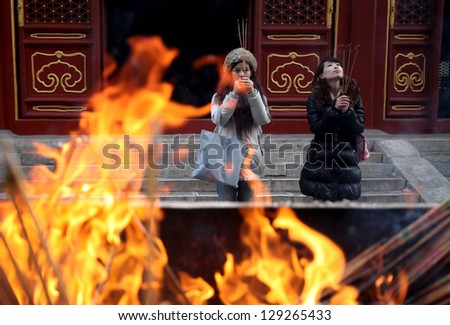 BEIJING, CHINA - CIRCA JANUARY 2013: Unidentified women praying in the Lama Temple on circa January 2013 in Beijing, China. It is one of the largest and most important Tibetan Buddhist monasteries in the world.