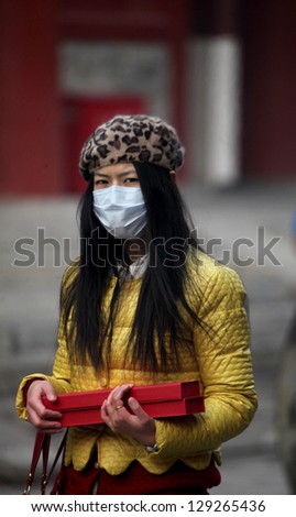 BEIJING, CHINA - CIRCA JANUARY 2013. Unidentified woman with mask in the Lama Temple on circa January 2013 in Beijing, China. It is one of the largest and most important Tibetan Buddhist monasteries in the world.