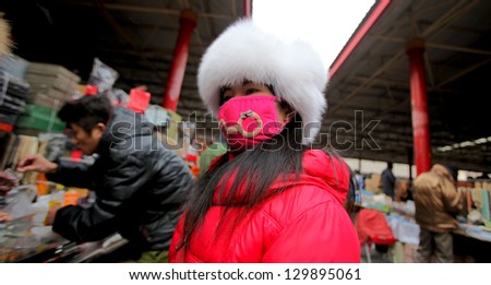 BEIJING, CHINA - CIRCA JANUARY 2013: Unidentified woman with mask on antiques market, 
