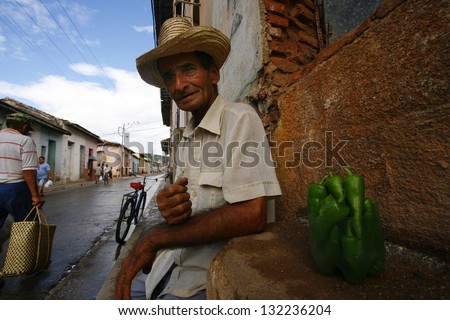 TRINIDAD, CUBA - CIRCA AUGUST 2006: Man selling green peppers on circa August 2006 in Trinidad, Cuba. Over three quarters of Cuba food is imported from other countries.