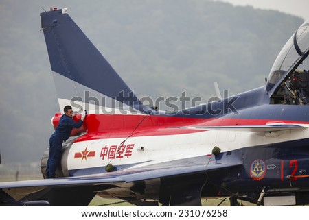 ZHUHAI, CHINA - NOV. 10. 2014:Man cleaning Chinese J-10 airplane before flight on Airshow China 2014 in Zhuhai.