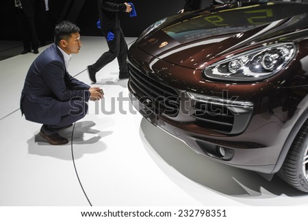 GUANGZHOU, CHINA - NOV. 20. 2014: Man looking Porsche Cayenne on the 12th China International Automobile Exhibition in Guangzhou, Guangdong province.
