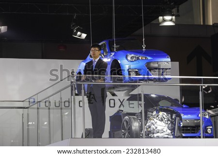 GUANGZHOU, CHINA - NOV. 20. 2014: Man on the Subaru stand standing in front of car model cuted in half on the 12th China International Automobile Exhibition in Guangzhou, Guangdong province.