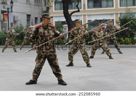GUANGZHOU, CHINA - FEB. 12. 2015:Military Academy cadets practice martial arts with bamboo sticks in park in Guangzhou, Guangdong province, February 12, 2015.