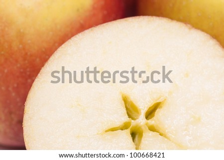 Braeburn apple slice in front of other apples