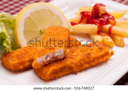 Breaded fish sticks with french fries and ketchup and lemon