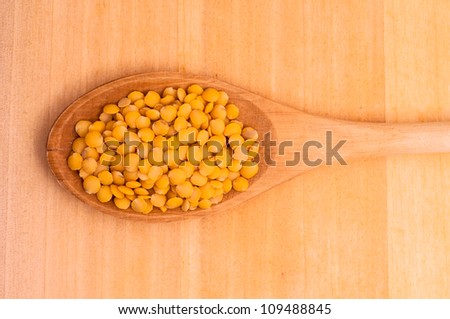 Close-up of yellow lentils on a wooden spoon