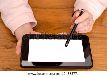 Two female hands with a touch pen on a tablet computer