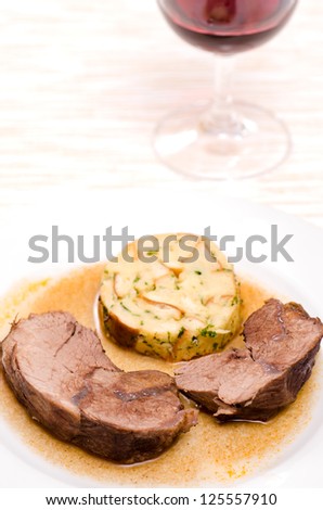 Stewed roast wild boar with dumpling and a glass of wine