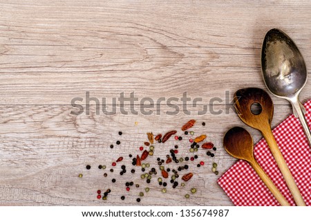 Wooden cooking spoon and old silver spoon on a checkered napkin