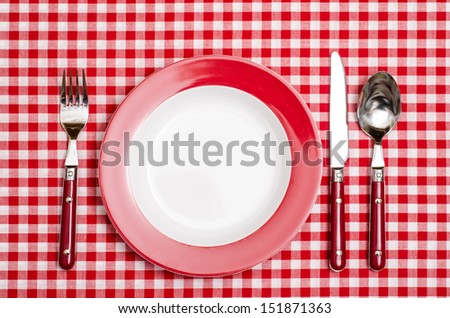 Red place setting with red checkered table cloth in a restaurant