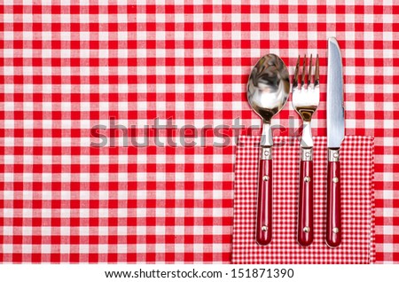Table in a restaurant with cutlery knife, fork and spoon in red