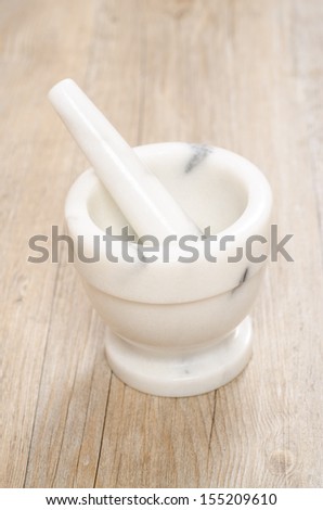 Mortar and pestle of marble on a old wooden board