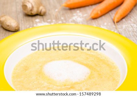 Foamed up carrot soup with coconut milk in a plate