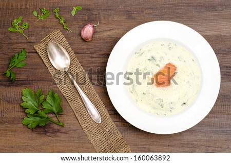 Fluffy herb soup with salmon in a white plate
