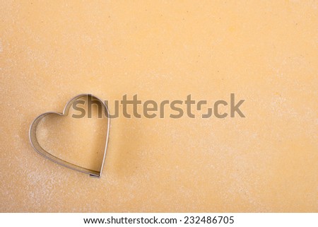 Dough with cutter in heart shape with free space