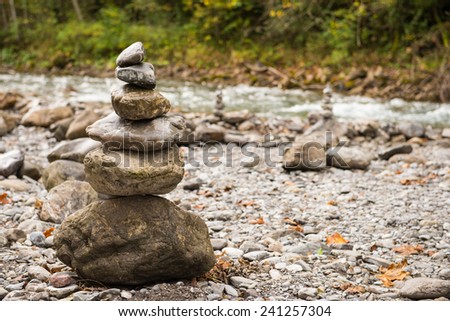 Stones in balance on top each other in front of a river