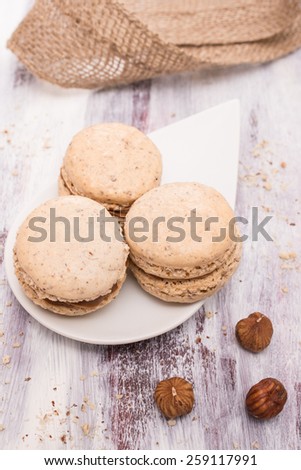 Hazelnut macarons on a plate in vertical format