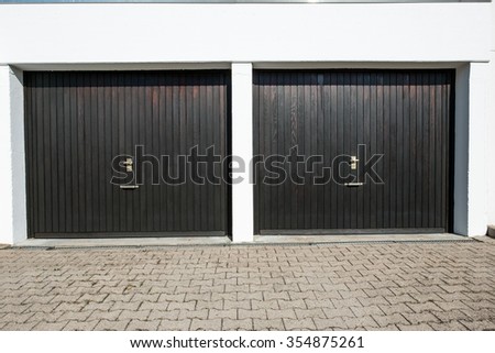 Driveway with 2 garage doors with knobs and lockers