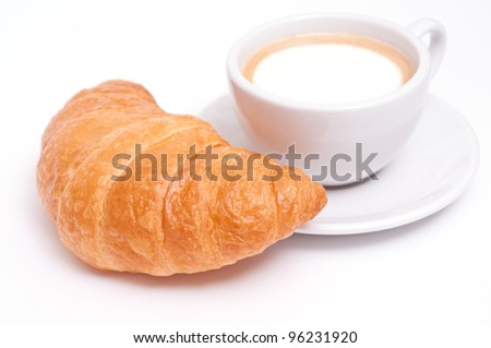 Cup of cappuccino witha french croissant and a white background