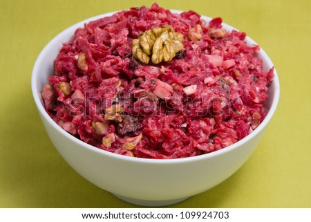 Salad with beets, dried plums, nuts on a plate