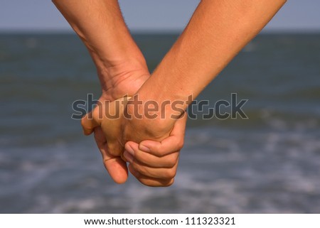 Couple of hands against the sea view