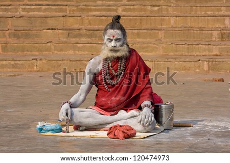 VARANASI INDIA DEC 1 An unidentified naga baba sadhu sits on the ghat along the Ganges on December 1 2012 in Varanasi India Tourism has drawn many alleged fake sadhus to Varanasi VARANASI INDIA DEC 1 An unidentified naga baba sadhu sits on the ghat along the Ganges on December 1 2012 in Varanasi India Tourism has drawn many alleged fake sadhus to Varanasi