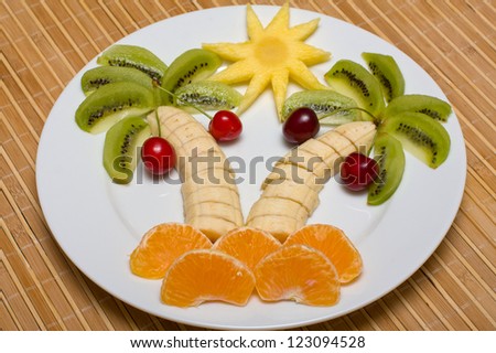Creative fruit dessert with kiwi, banana,cherry and orange palm tree shape