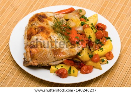 Fried chicken legs with vegetables served on the white plate