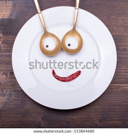 Fun plate - facial image on the plate with spoons and pepper