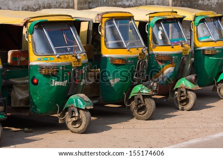 AGRA, INDIA - NOVEMBER 26: Auto rickshaw taxis on a road on November 26, 2012 in Agra, India. These iconic taxis have recently been fitted with CNG powered engines in an effort to reduce pollution