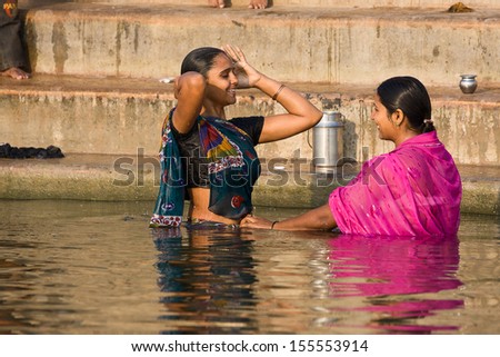 VARANASI, INDIA - NOVEMBER 30: An unidentified woman wash themselves in the river Ganges on November 30, 2012 in the holy city of Varanasi, India. The holy ritual is held every day.