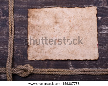 Old burnt paper on wood with rope frame background